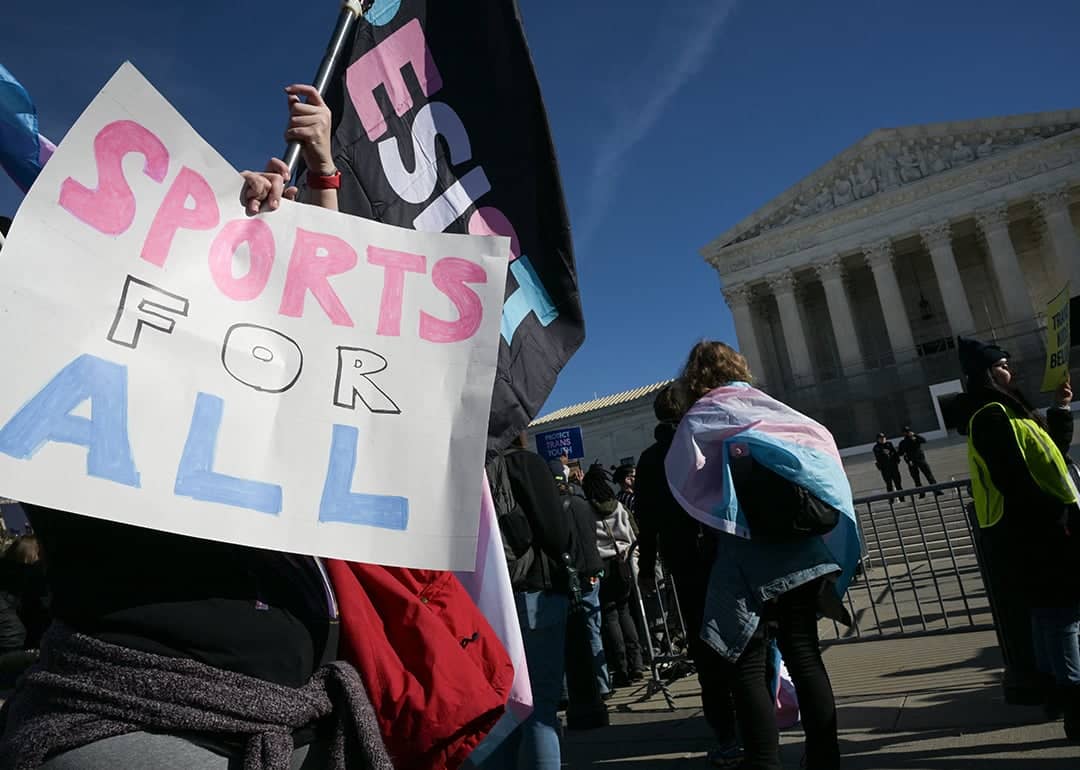 LGBTQ+ rights advocates rally outside the US Supreme Court as justices hear arguments in challenges to state bans on transgender athletes in women's sports on January 13, 2026, in Washington, DC.
